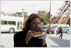 Eve, enjoying a waffle with nutella, in front of the Eiffel Tower.