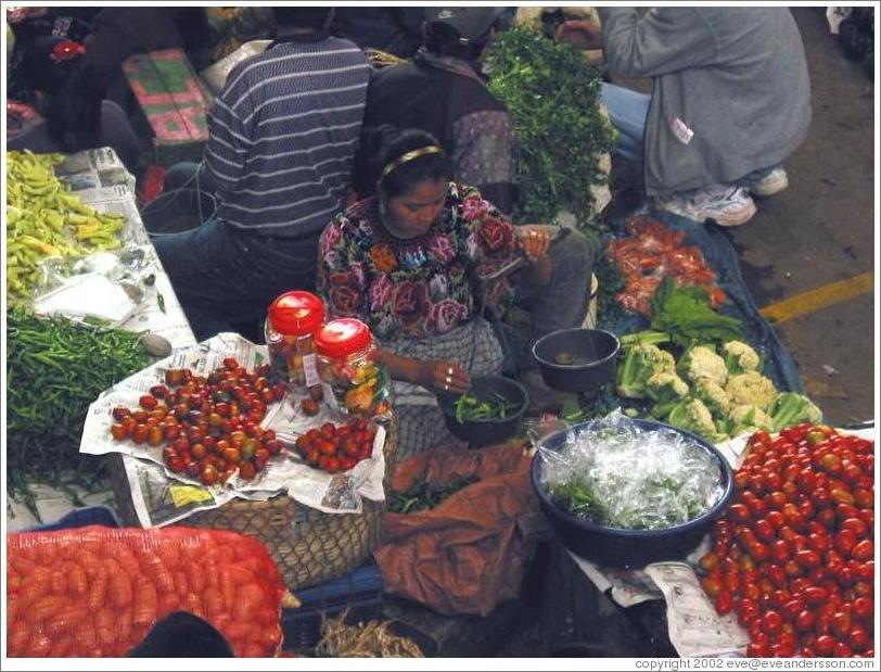 Woman weighing goods, food market.