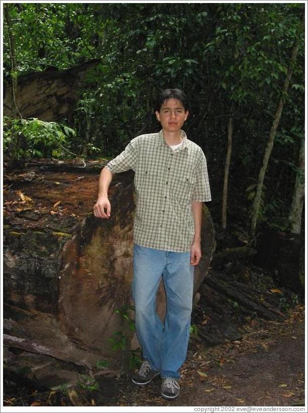 Jopez in front of very old tree trunk.