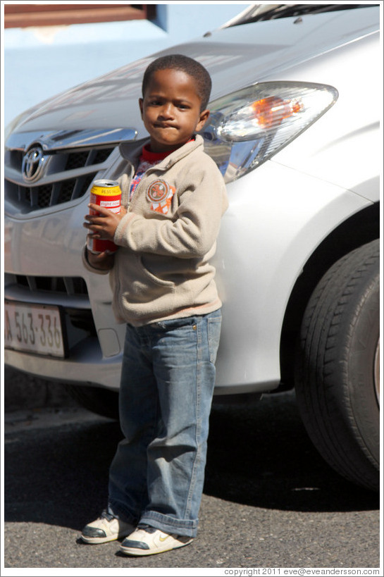 Boy drinking a can of Coke. Chiappini Street, Bo-Kaap.