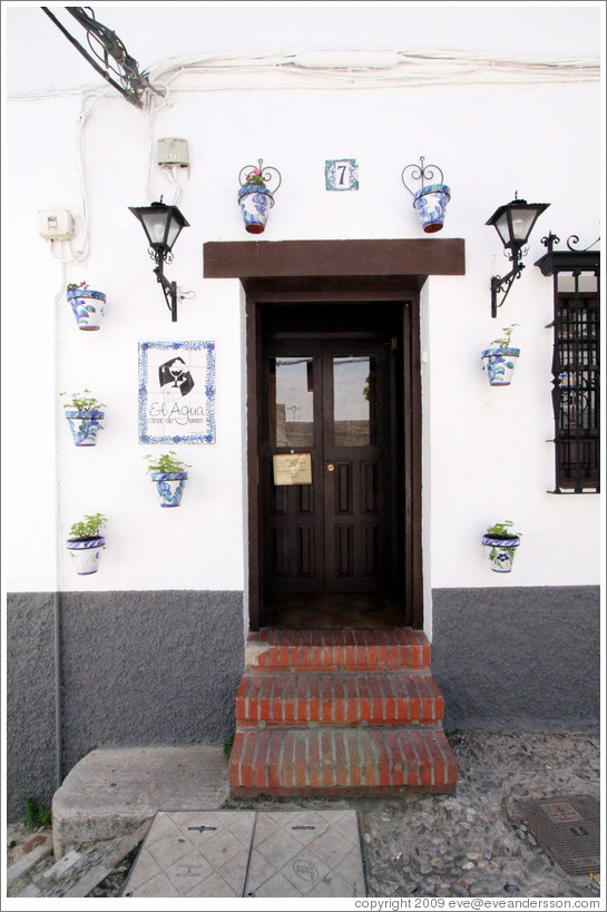Door of El Agua Casa De Vinos, decorated with flower pots.  Placeta del Aljibe de Trillo.  Albaic?