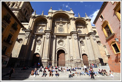 People enjoying the sun on steps in from of the Granada Cathedral.