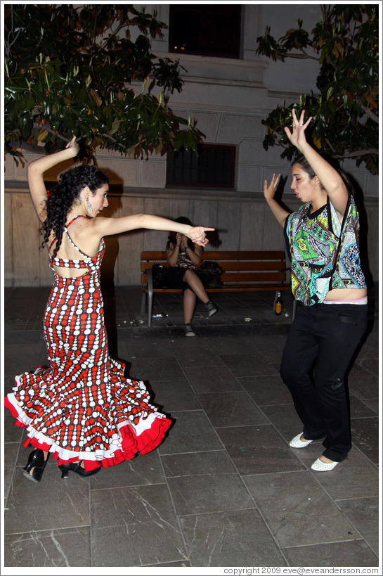 Women dancing flamenco on the street at night during the Fiesta de las Cruces.  Plaza del Carmen.  City center.